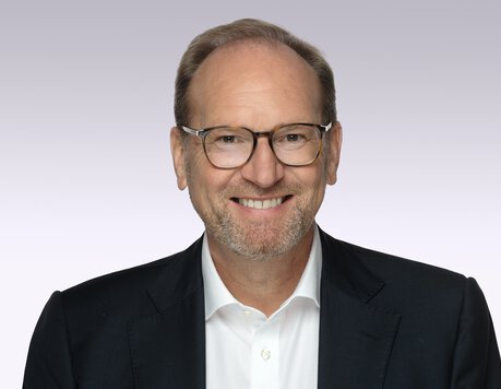 laechelnder-mann-mit-brille-sakko-hemd