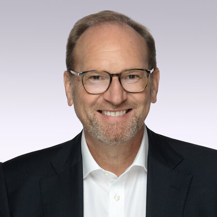 laechelnder-mann-mit-brille-sakko-hemd