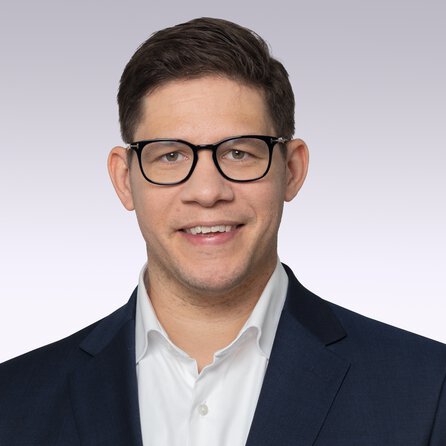 junger-mann-mit-brille-laechelnd-im-hemd-und-sakko